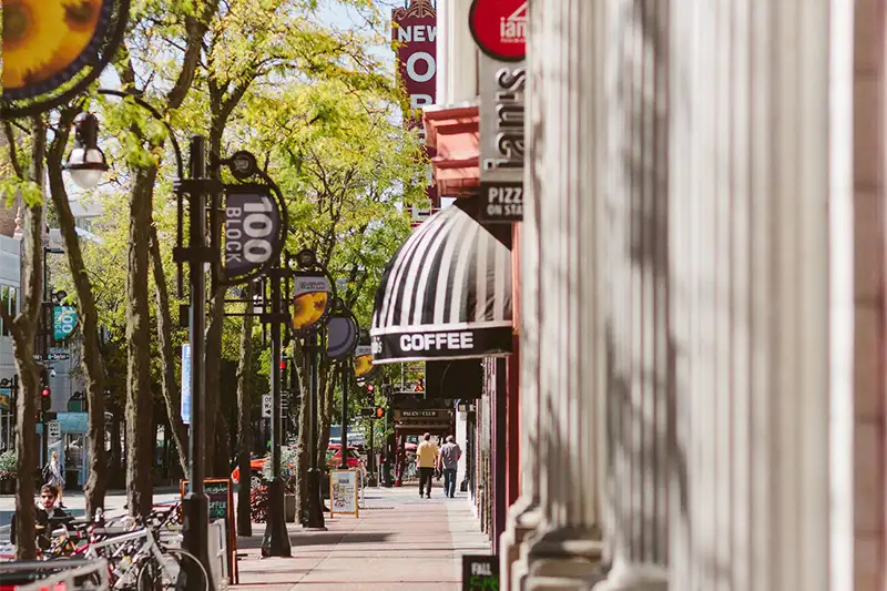 A scenic view of the 100 block of State Street in Madison, WI, featuring local coffee shops and boutiques just a short walk from The Buckingham Inn.
