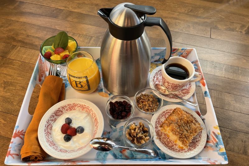 In-room breakfast tray at The Buckingham Inn featuring fresh yogurt with berries, granola, orange juice, hot coffee, and a gourmet pastry for a private Madison B&B experience.